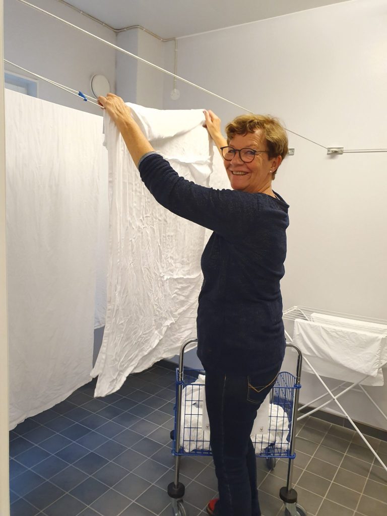 Volontär hänger upp tvätt i tvättstugan på Ronald McDonald Hus Linköping
